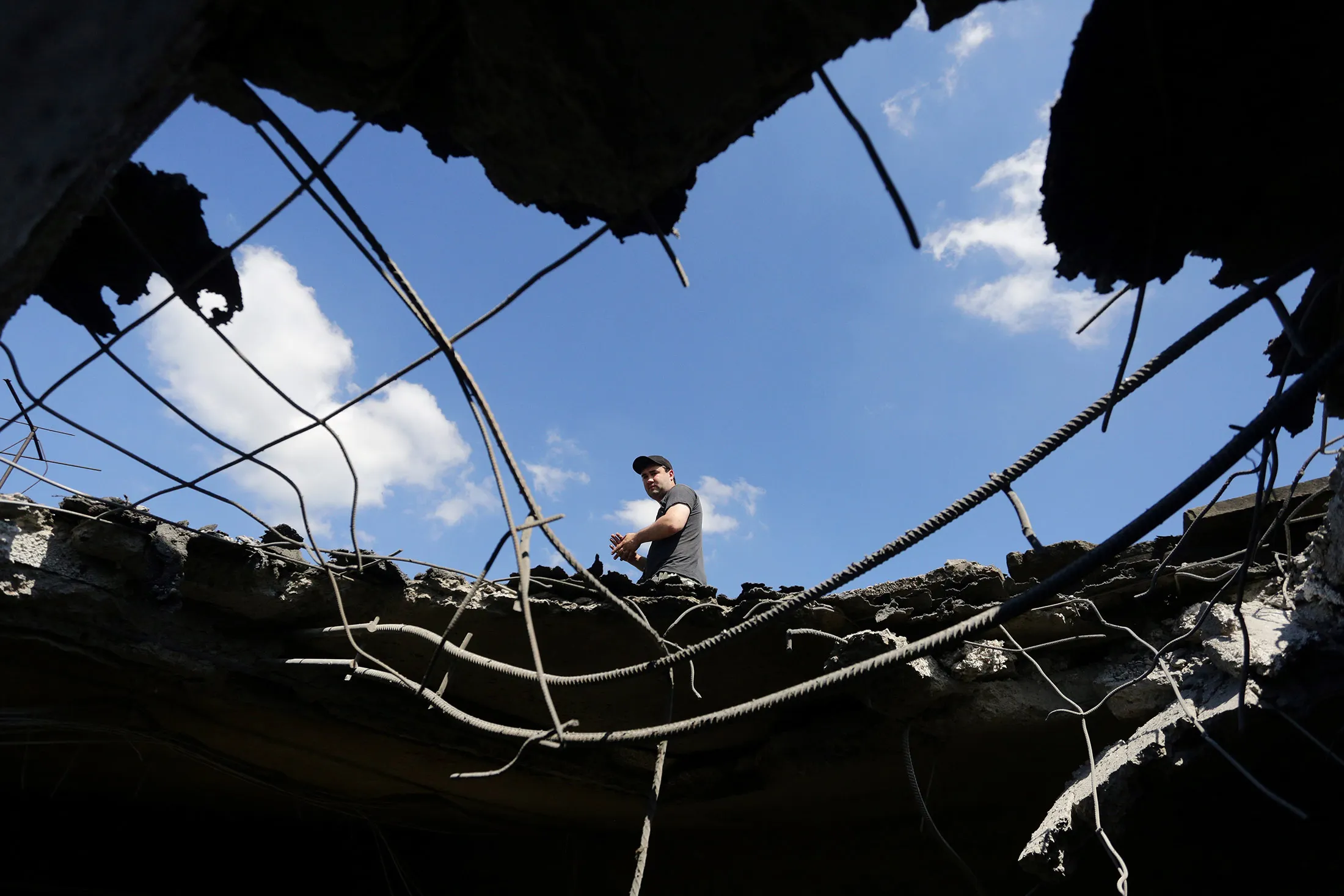 A resident looks through a hole into an apartment building destroyed from shelling on June 24.
