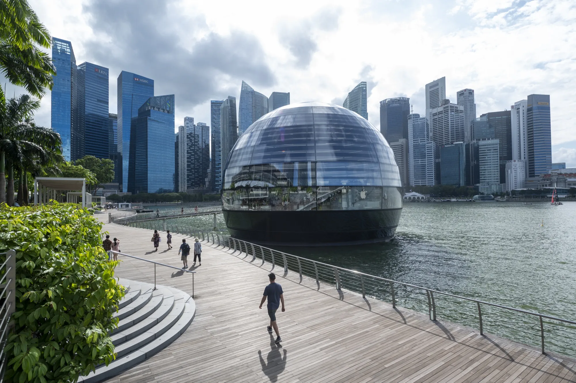 People walk along the Marina Bay Sands boardwalk in Singapore.