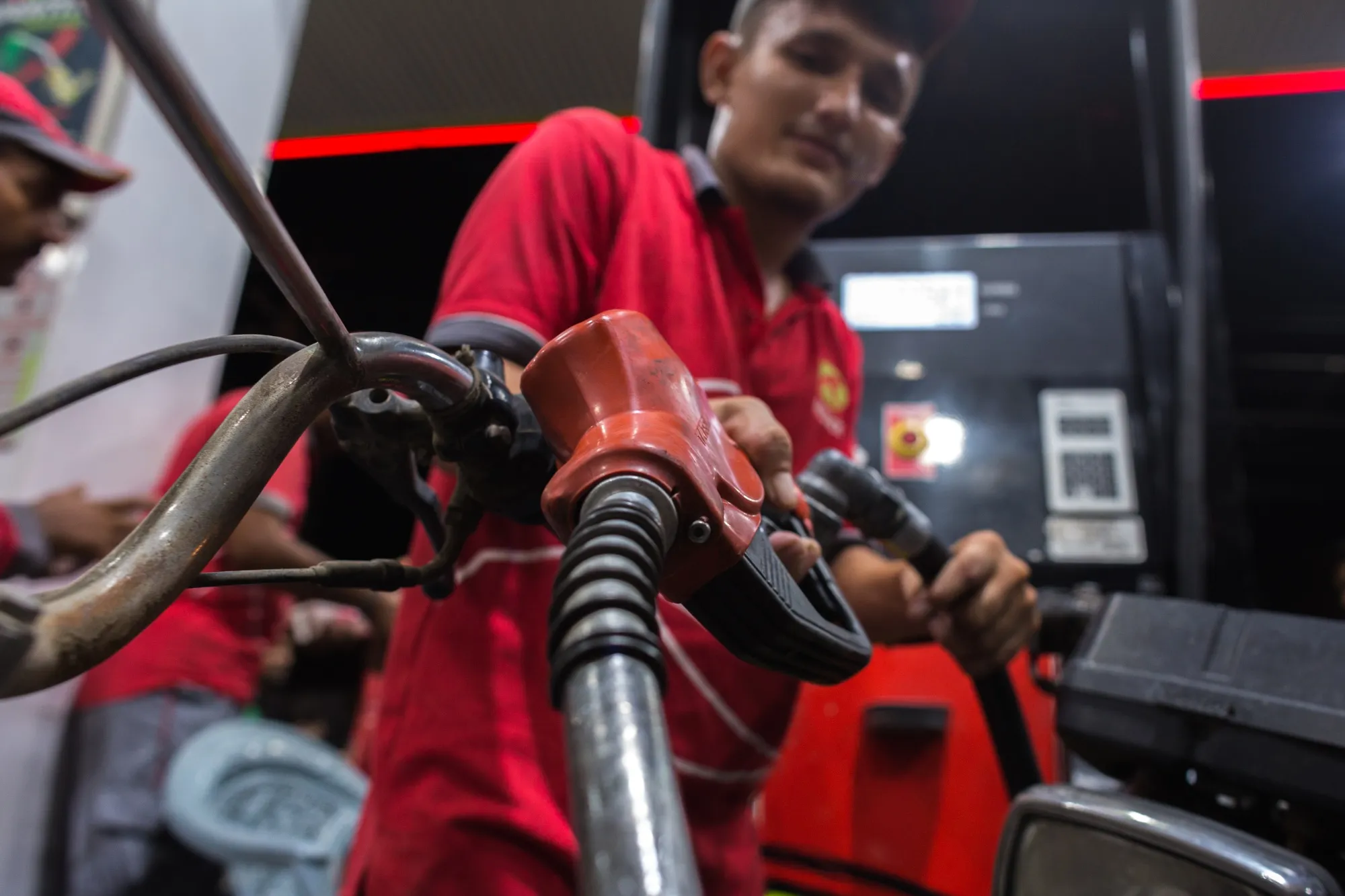 A worker fills up a motorcycle with fuel at a gas station in Karachi, Pakistan.