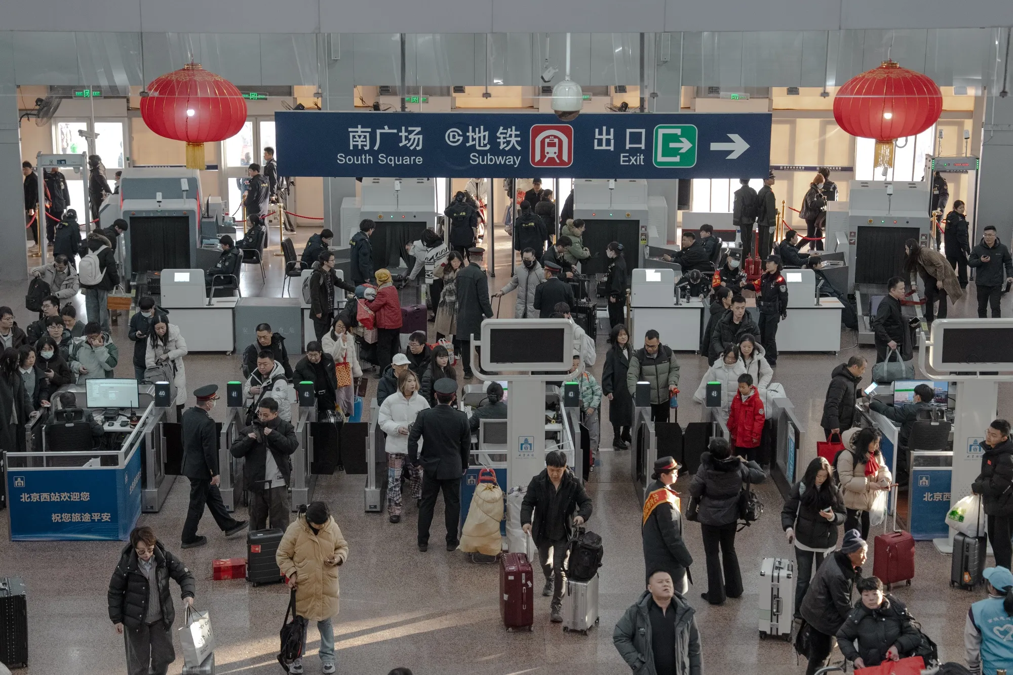 Travelers queue to pass through the ticket gates at Beijing West Railway Station ahead of Lunar New Year holidays in Beijing, China.