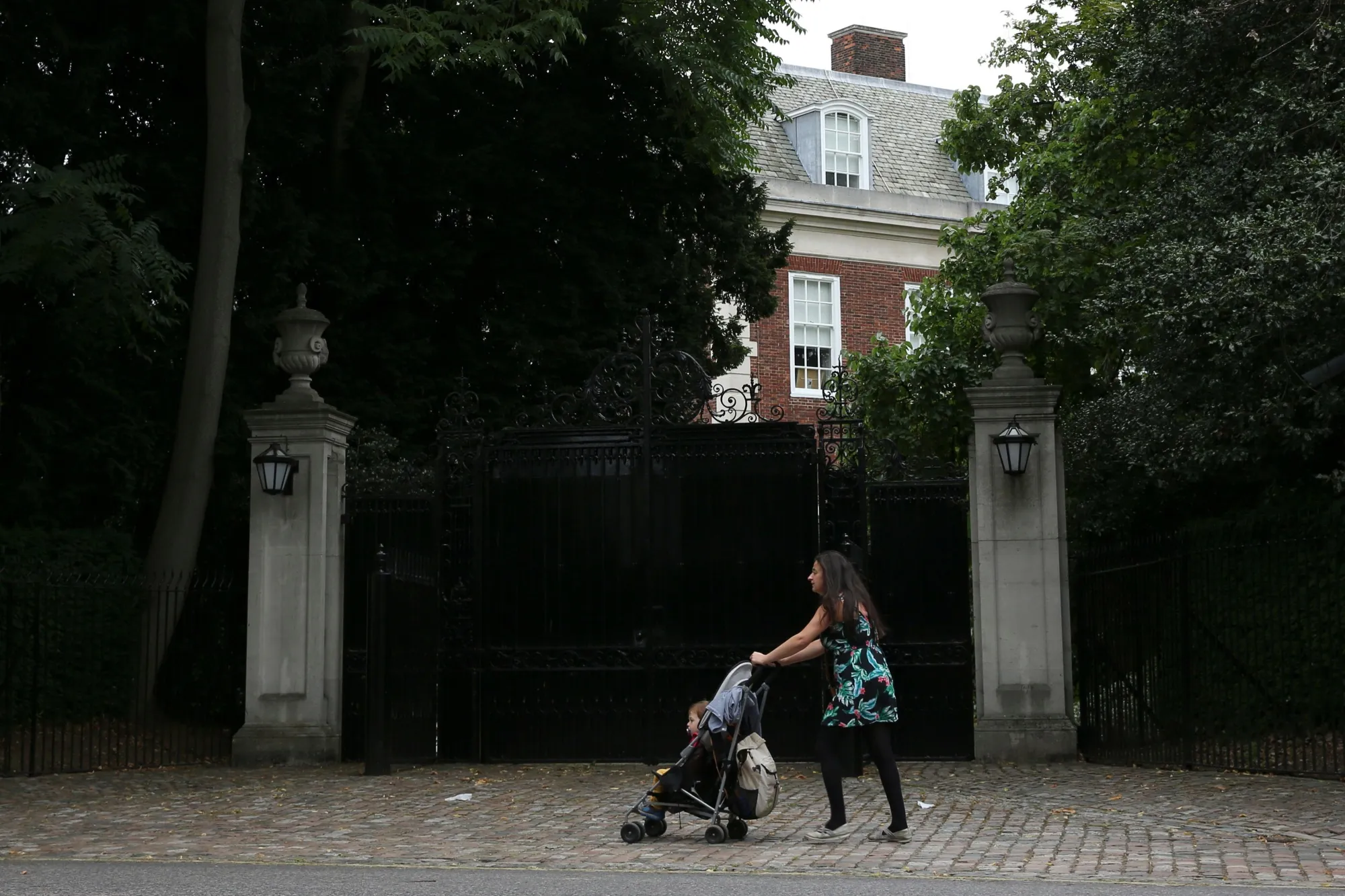 A woman pushes a stroller past&nbsp;Regent's Park, London.&nbsp;