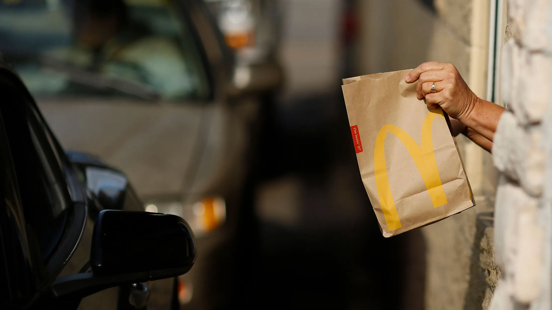 A worker passes a bag of food to a customer at the drive-thru window at a McDonald's fast food restaurant in White House, Tennessee, on Jan. 18, 2017.
