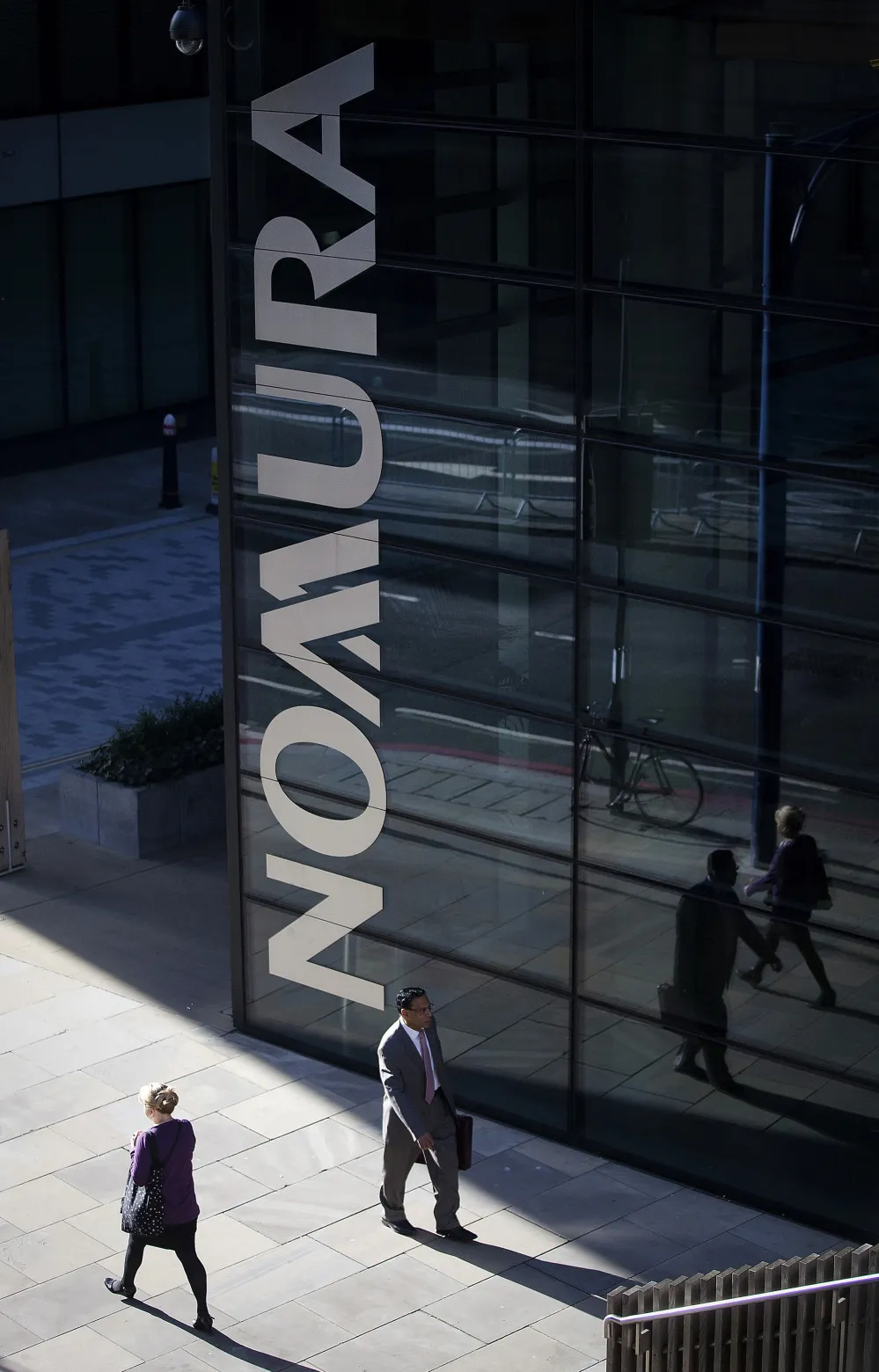 Pedestrians walk past the U.K. headquarters of Nomura Asset Management Ltd, part of the Nomura Holdings Inc group, in London, U.K.
