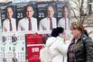 People pass election posters for the Progressive Bulgaria coalition leader Rumen Radev in Sofia, on April 20.