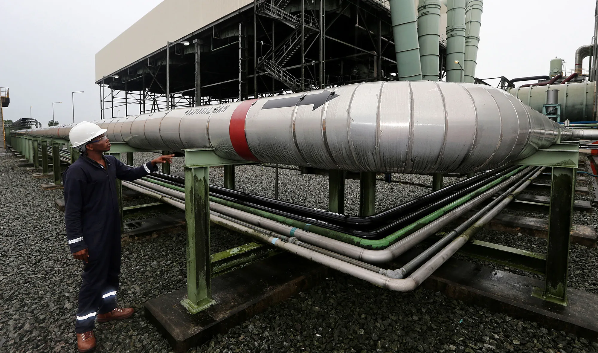 A worker inspects a natural gas pipeline at a plant in Afam, Nigeria.