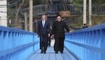 Moon Jae-in and Kim Jong Un cross a bridge in the Demilitarized Zone.