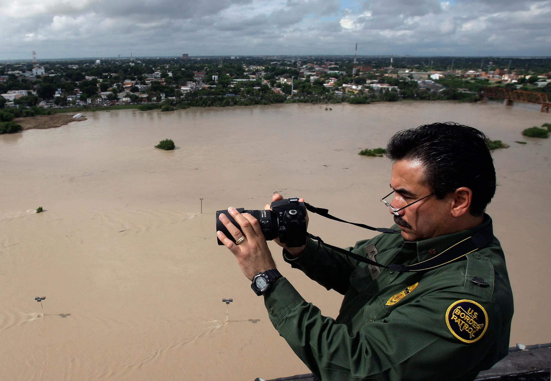 A U.S. Border Patrol officer takes photographs along the Rio Grande River in Texas.
