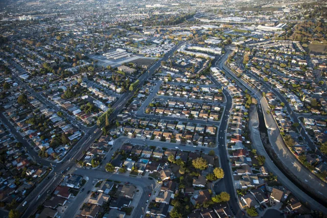 Houses stand in this aerial photograph taken above Alameda, California, U.S., on Monday, Oct. 5, 2015. With tech workers flooding San Francisco, one-bedroom apartment rents have climbed to $3,500 a month, more than in any other U.S. city.