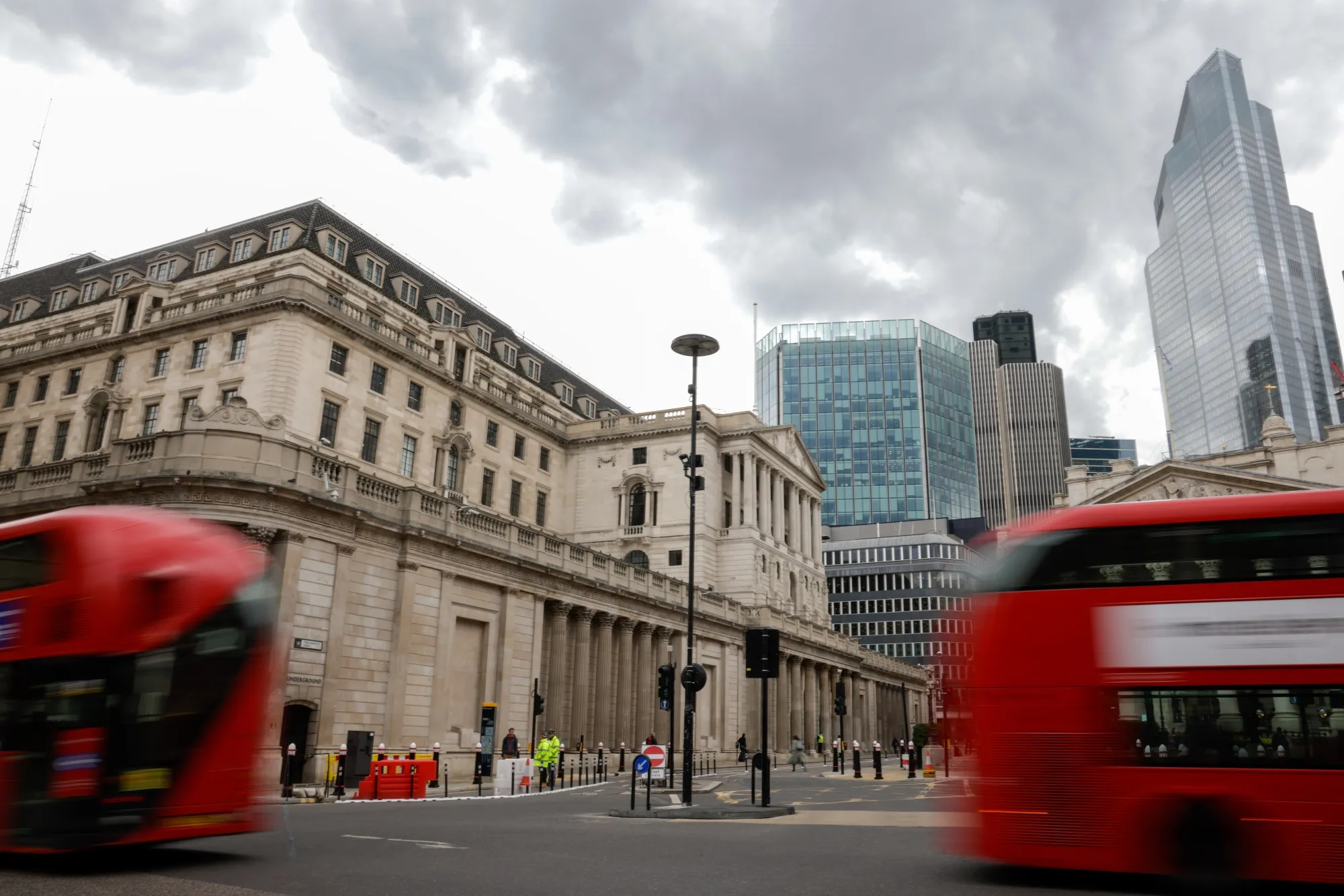 Double decker buses pass the Bank of England in London.