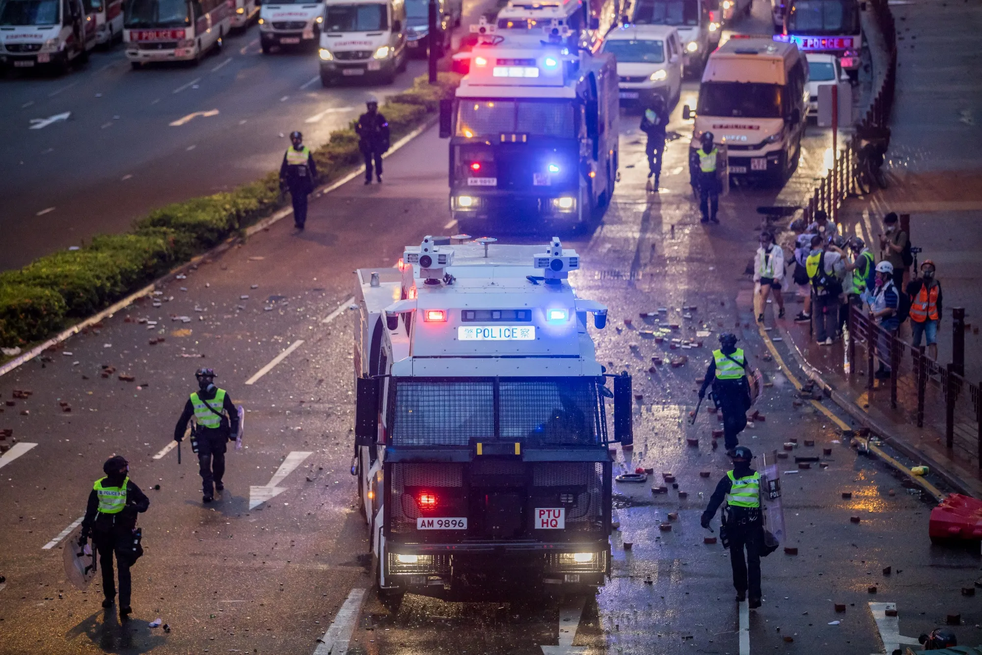 Riot police walk alongside water cannon vehicles during a protest in the Tsuen Wan district of Hong Kong, Aug. 25.