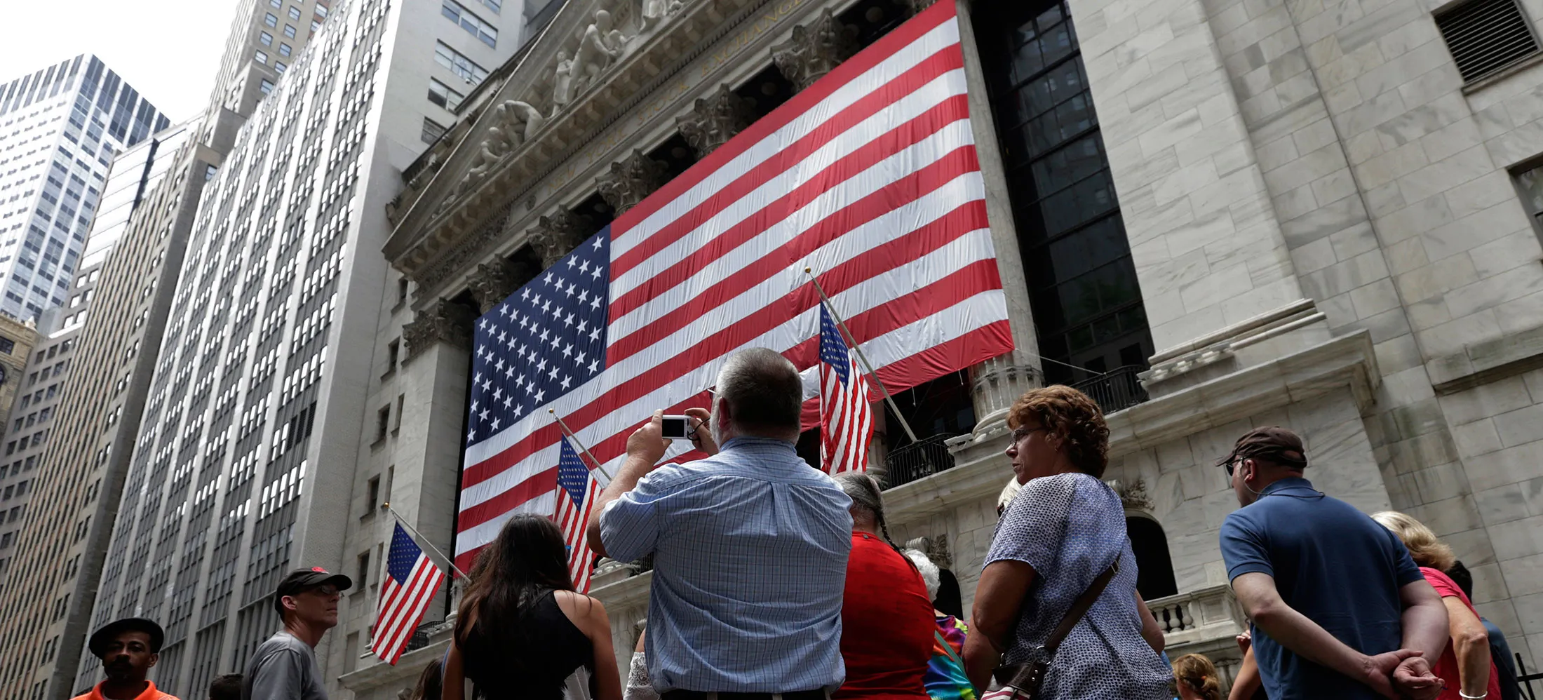 Tourists take pictures outside the New York Stock Exchange.
