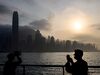 People wear face masks, as a preventative measure against the COVID-19 coronavirus, as they take pictures of Hong Kong skyline in Tsim Sha Tsui on February 12, 2020. - The death toll from the COVID-19 coronavirus epidemic climbed past 1,100 on February 12 but the number of new cases fell for a second straight day, raising hope the outbreak could peak later this month. (Photo by Philip FONG / AFP) (Photo by PHILIP FONG/AFP via Getty Images)