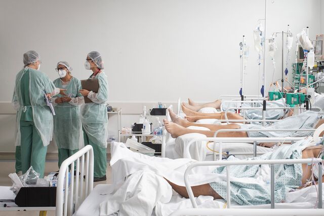 Healthcare workers hold a meeting while treating patients inside a Covid-19 intensive care unit (ICU) at a field hospital in the Heliopolis favela of Sao Paulo, Brazil, on Friday, March 19, 2021. States across the country are seeing ICU bed shortages and healthcare systems on the brink of collapse, including Sao Paulo which has hit 91% capacity.