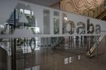 Employees and visitors are reflected on a glass panel at the Alibaba Group Holding Ltd. headquarters in Hangzhou, China.