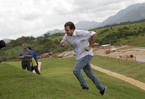 Rio’s Mayor Eduardo Paes runs up a hill to speak to journalists at Deodoro Olympic Park in April.