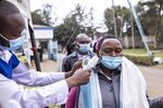 Residents have their temperature scanned at Mbagathi Hospital during a Covid-19 vaccination drive in Nairobi.