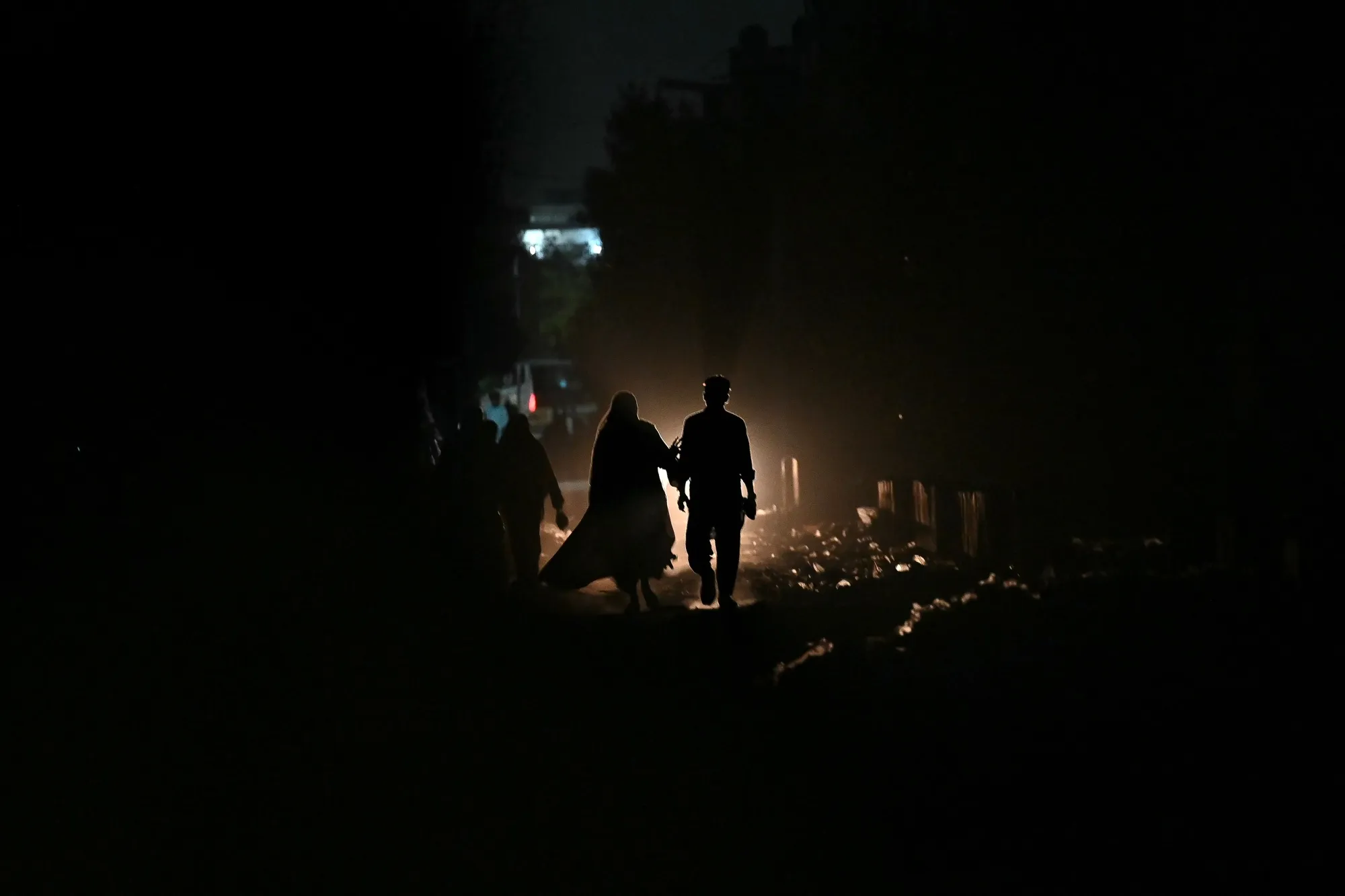 Commuters walk along a street during a power cut in Karachi on April 19.