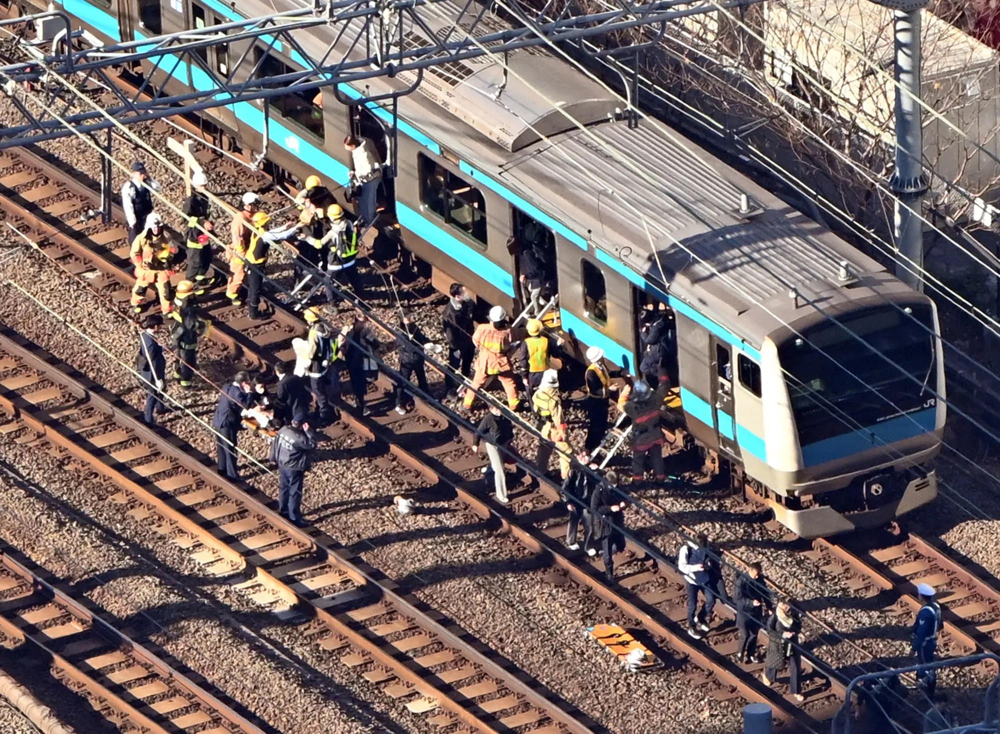Passengers disembark a train and walking on the tracks in Minato Ward, Tokyo, on Jan. 16.