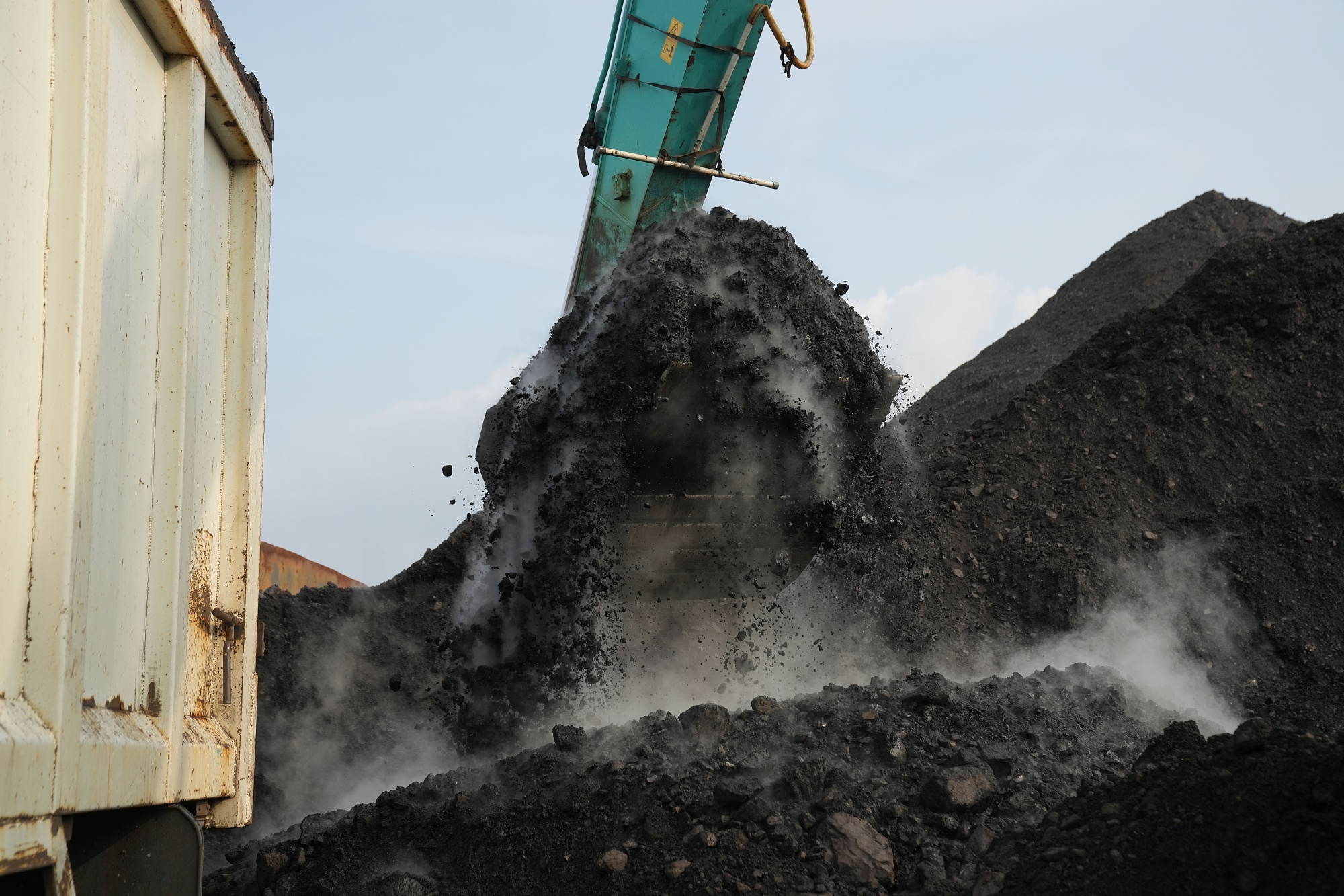 An excavator loads coal onto a dump truck at Cirebon Port in West Java, Indonesia.