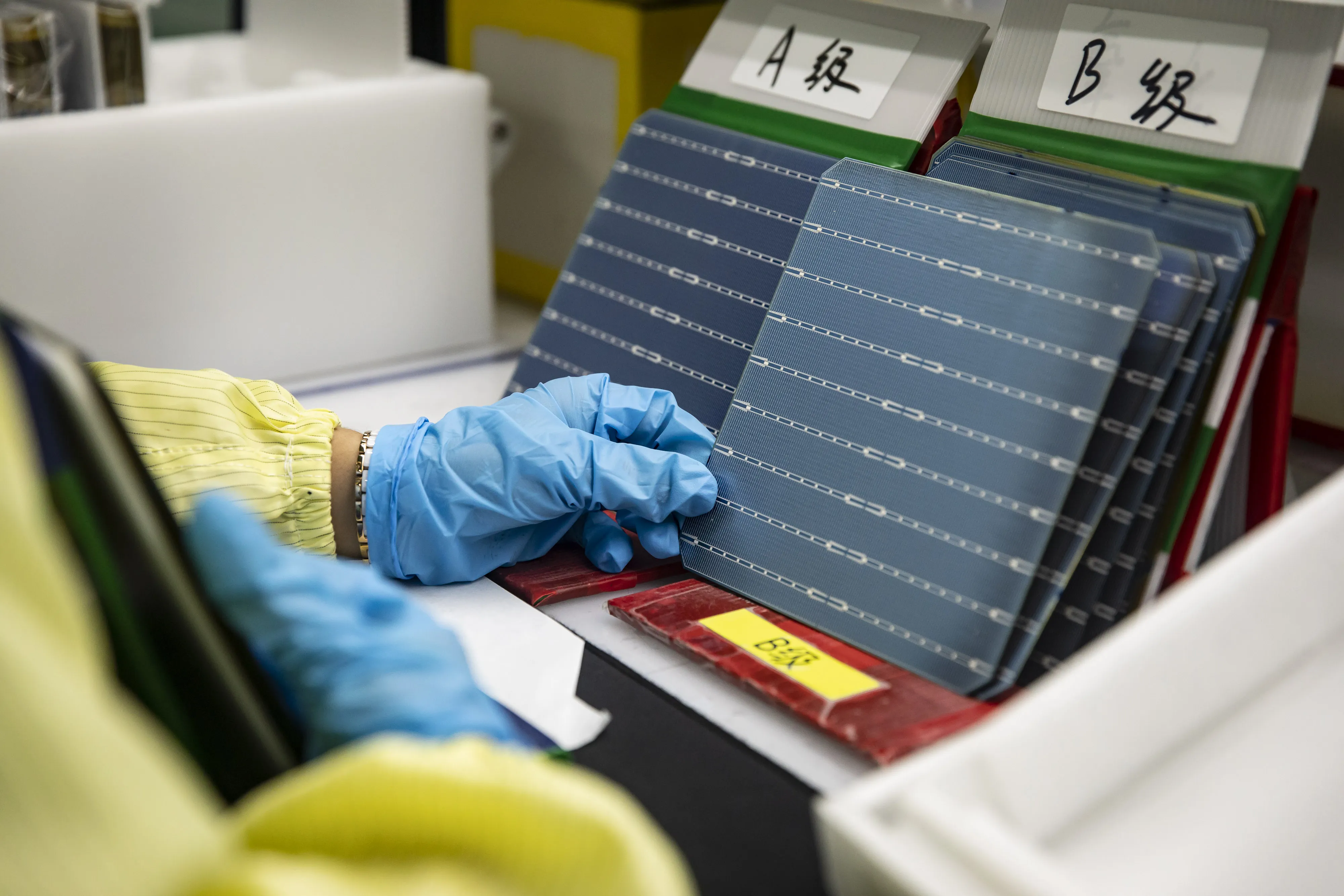 An employee inspects photovoltaic cells on the production line at the Longi Green Energy Technology plant in Xi'an, Shaanxi Province, China.
