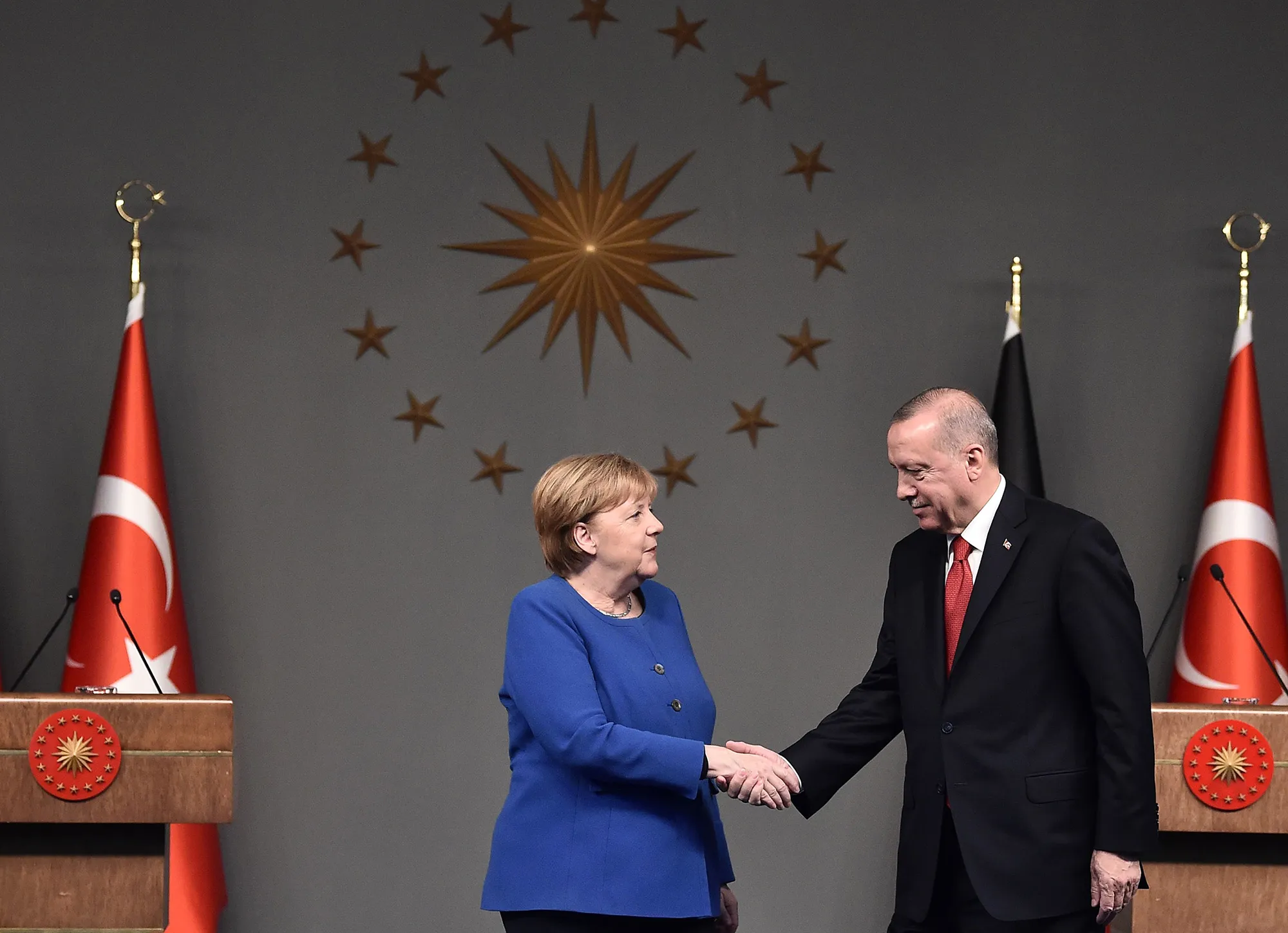 Recep Tayyip Erdogan and Angela Merkel shake after a joint news conference on Jan. 24.