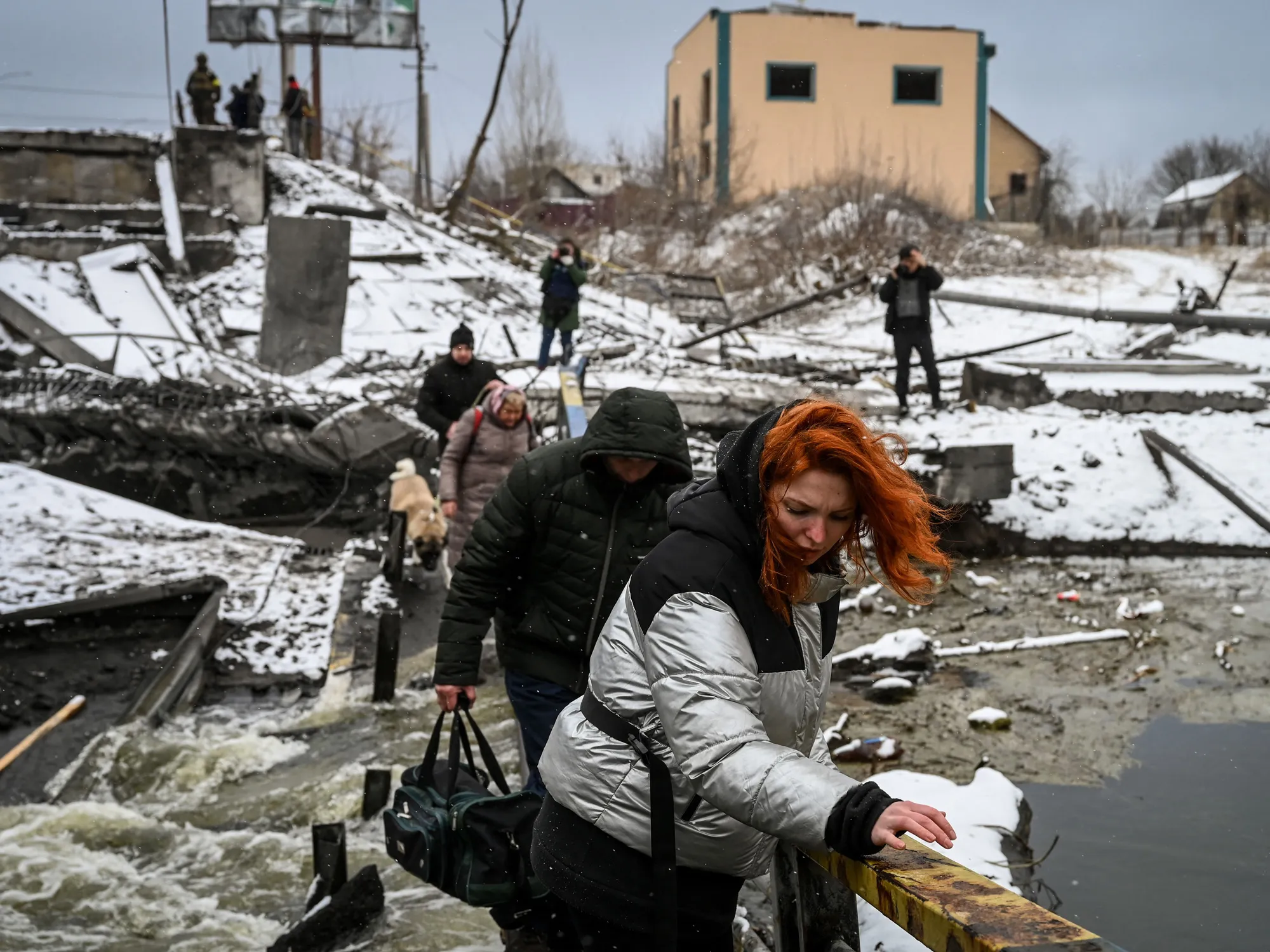 Civilians cross a river on a destroyed bridge near Kyiv, on March 1. The Ukrainian government said overnight that Russian troops were moving toward the city.