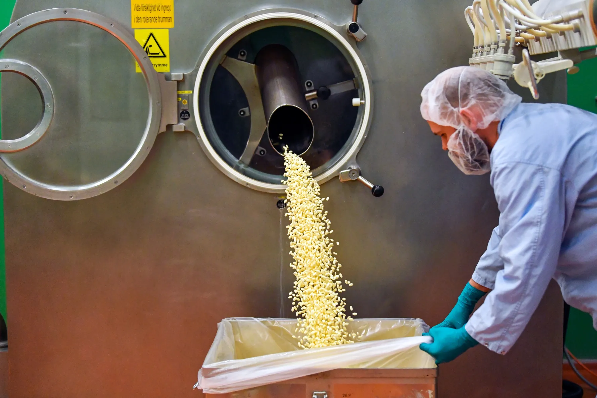 Newly coated tablets flow into to a container at AstraZeneca Plc's plant in Sodertalje, Sweden.