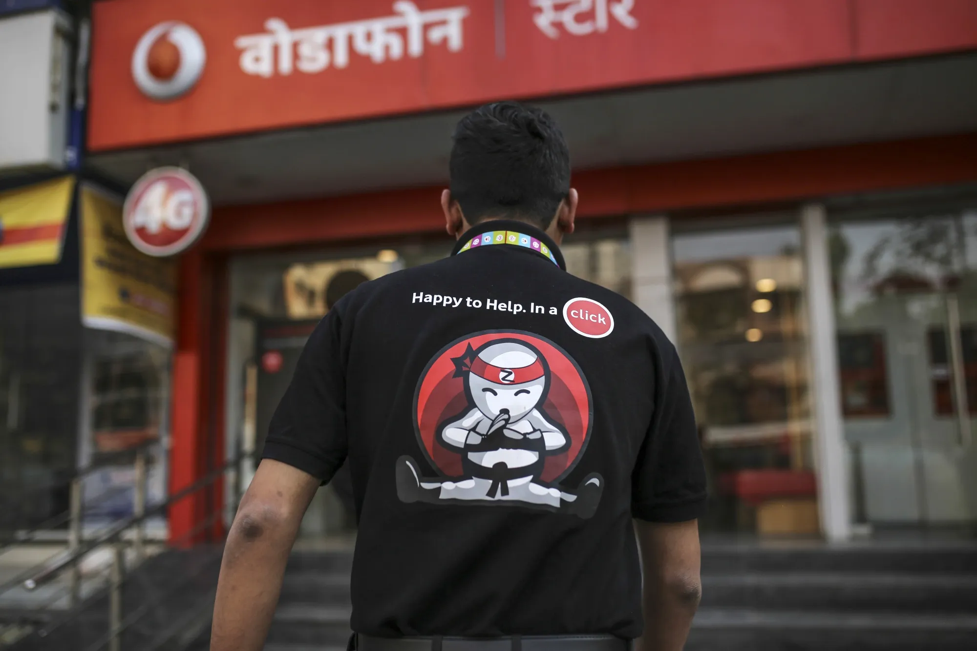 A Vodafone Idea Ltd. employee near a store in Mumbai.