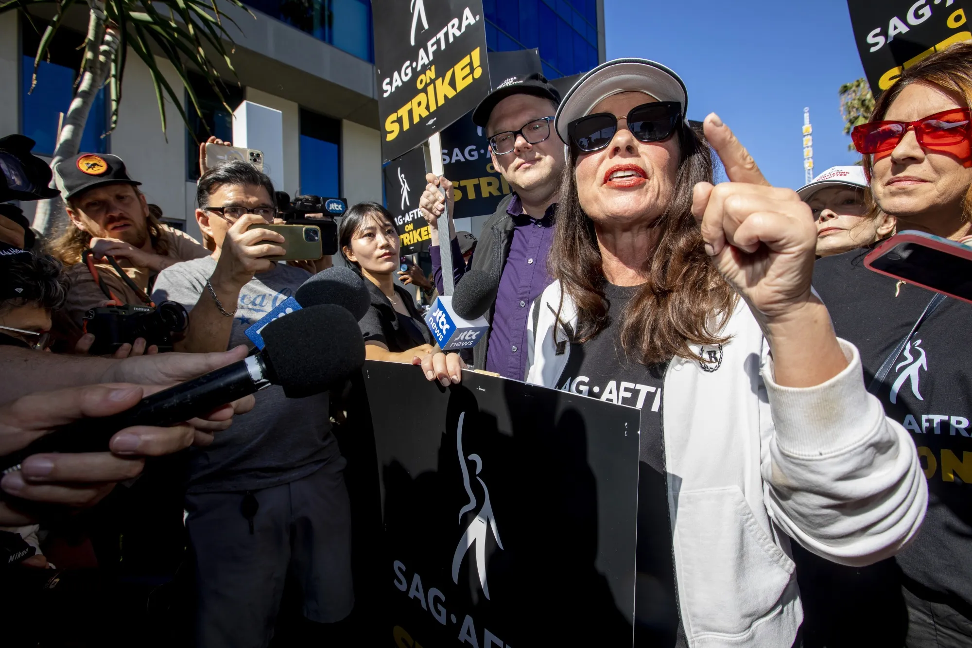 Actor Fran Drescher, president of SAG-AFTRA, speaks to members of the media as union members and supporters picket outside Netflix’s Los Angeles studios in July.