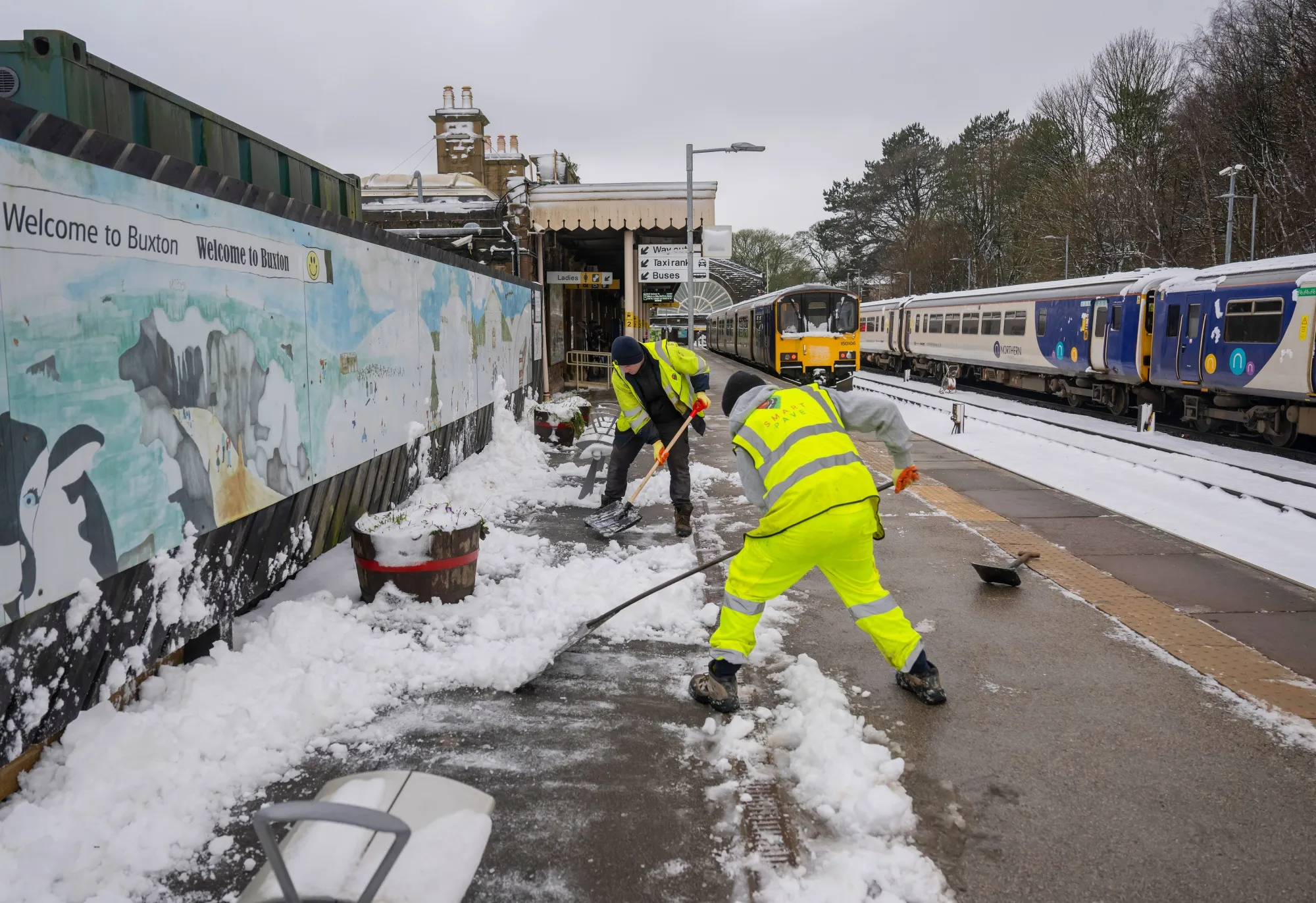Workers clear snow on the platform in Buxton, UK, on Jan. 9.