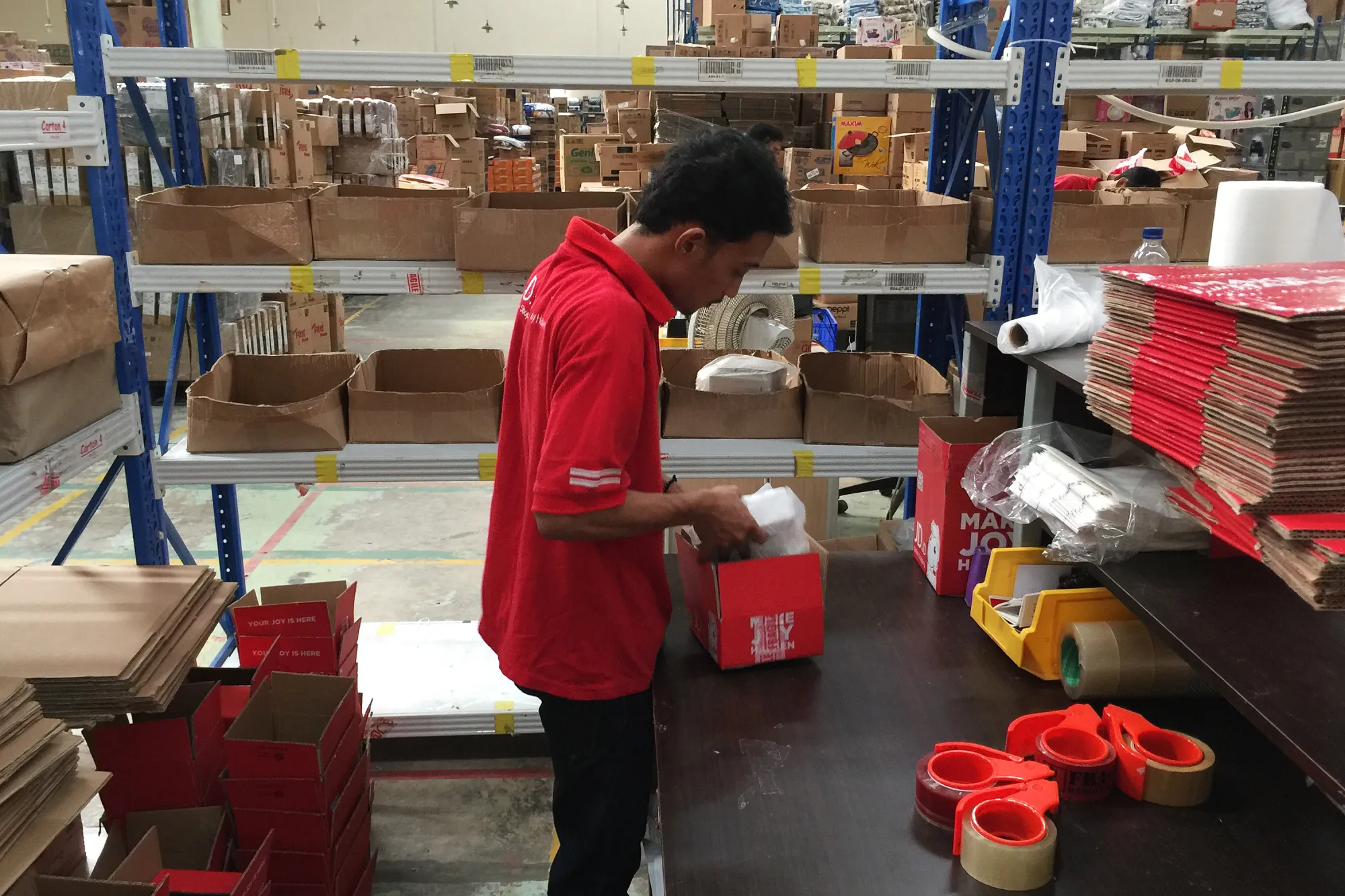 An employee packs an order at a JD.com warehouse in Depok, Indonesia.

