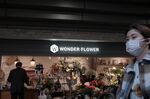 A pedestrian walks past a flower shop in the Ybisu district of Tokyo, Japan, on Friday, Dec. 17, 2021. Bank of Japan Governor Haruhiko Kuroda told reporters he hasn't heard anything to suggest that the omicron variant of coronavirus is impacting Japanese consumer behavior, but the bank is watching overall developments closely.