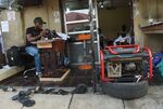 A tailor uses a generator for power in Lagos.