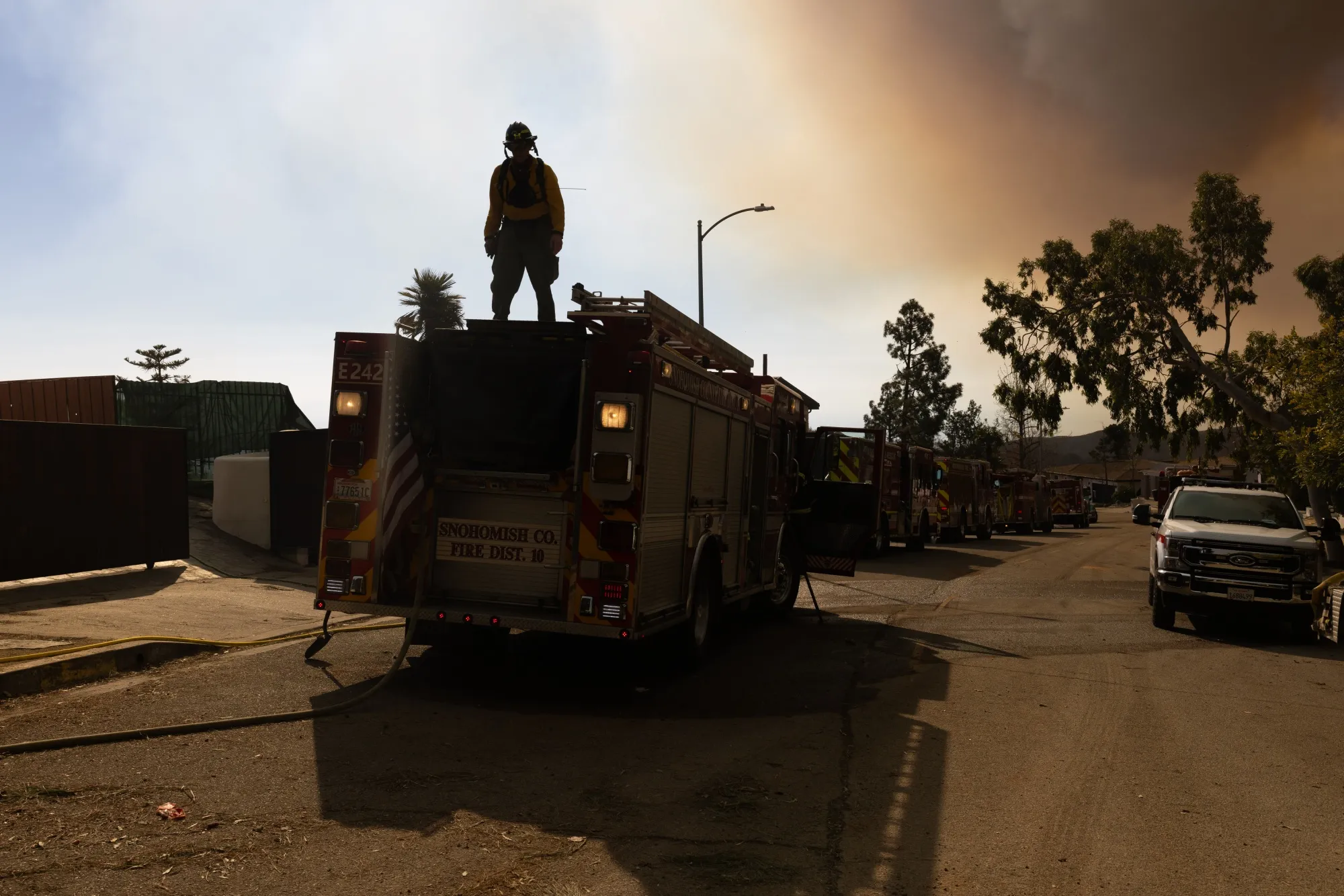 A firefighter works on top of a truck during the Palisades Fire near the Sullivan Canyon area of Los Angeles, on Jan. 11.