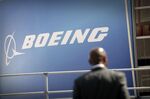 A visitor stands near a Boeing logo at the Farnborough Air Show prior to the event's opening in Hampshire, UK, on Sunday, July 13, 2008. The air show will be open from July 14-20.