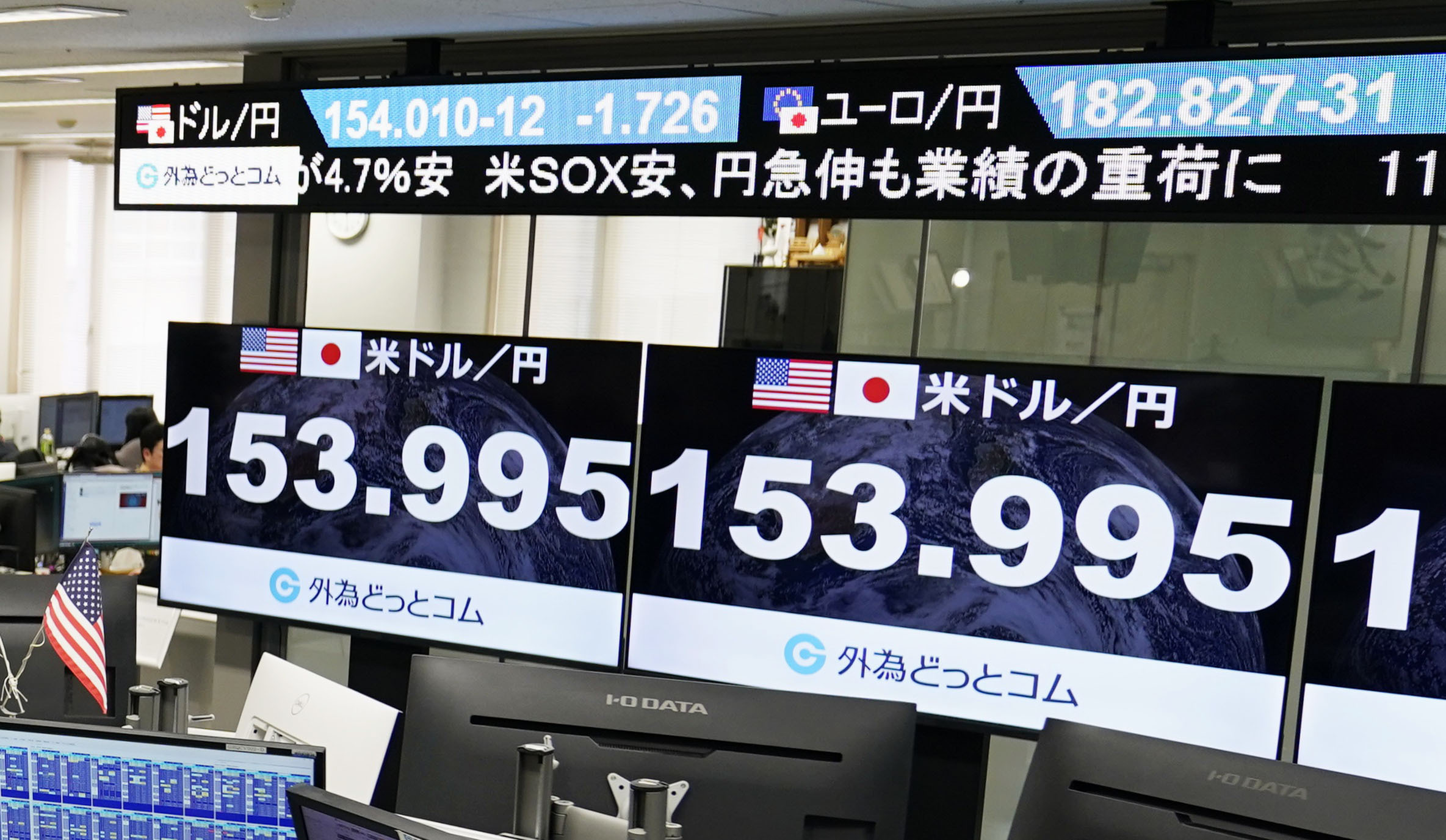 Financial monitors at a currency trading company in Tokyo show the U.S. dollar hitting a two-month low in the upper 153 yen range on the morning of Jan. 26, 2026, amid lingering wariness of a possible yen-buying intervention by U.S. and Japanese authorities. (Photo by Kyodo News via Getty Images)