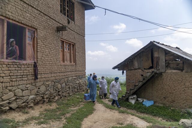A 'door-to-door' Covid-19 vaccination team depart a home after inoculating the residents during a vaccination drive at a village in the Budgam district of Jammu and Kashmir, India, on Tuesday, August 03, 2021. The average vaccination rate in India is estimated at 5.31 million doses per day. At this rate, it will take a projected 9 months to cover 75% of the population with a two-dose vaccine.