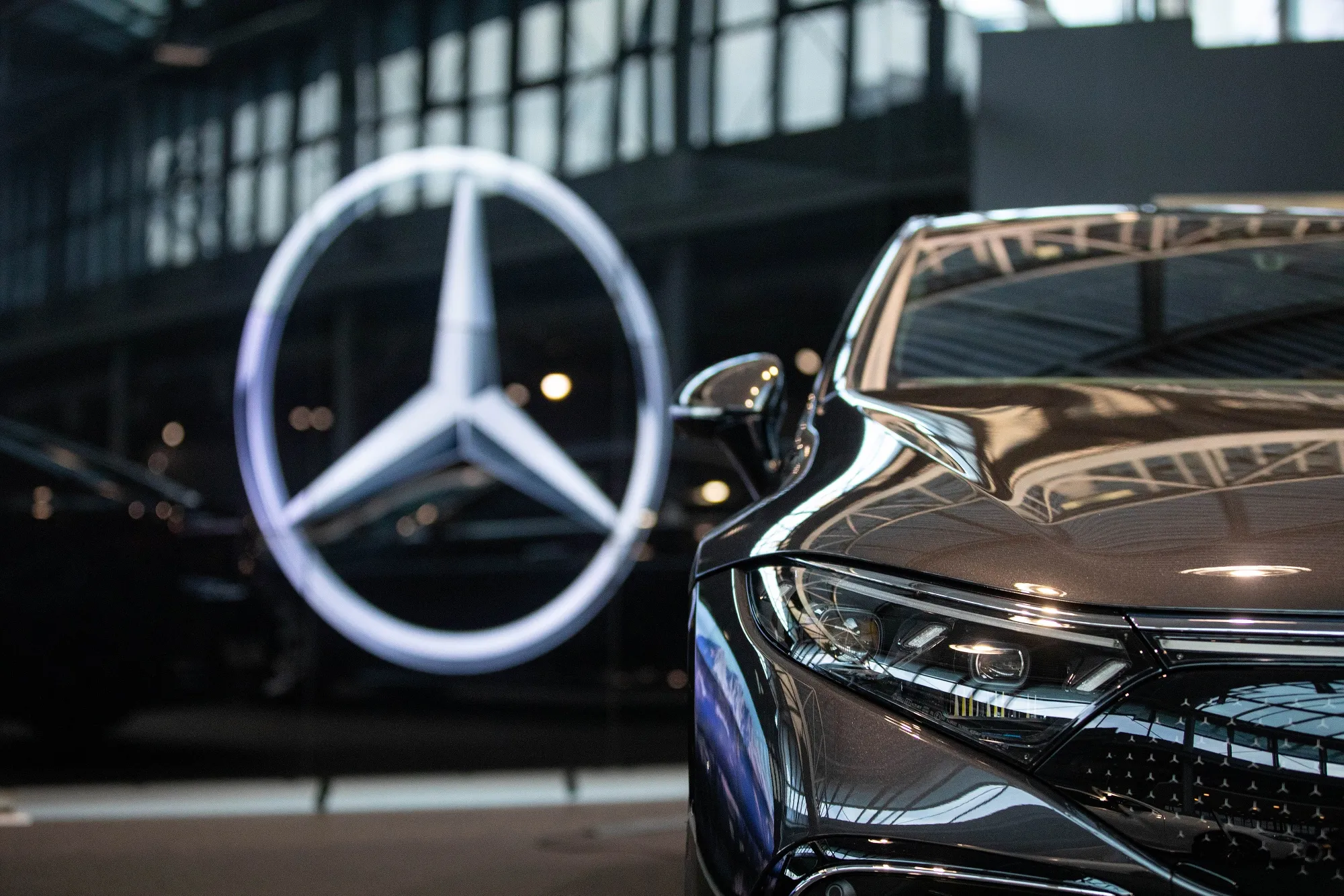 The Mercedes-Benz logo near an automobile inside a Mercedes-Benz AG Showroom in Berlin, Germany. The Canadian government is trying to land supply-chain deals with major German automakers in the face of fierce competition from the US on electric-vehicle production.