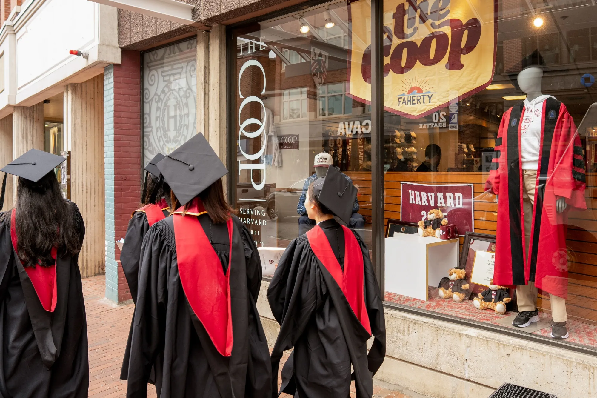 Harvard University students wearing graduation gowns walk past a bookstore near the Harvard University campus in Cambridge, Massachusetts, US, on Thursday, May 29, 2025.&nbsp;