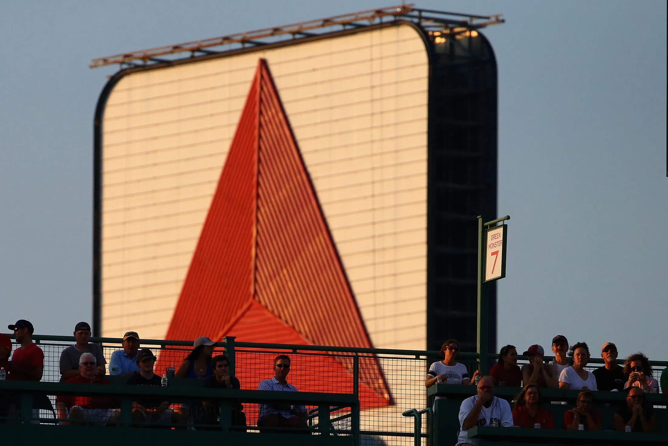 BOSTON, MA - JULY 22: Fans sit on the Green Monster in front of the Citgo sign during the first inning of the game between the Boston Red Sox and the Minnesota Twins at Fenway Park on July 22, 2016 in Boston, Massachusetts.
