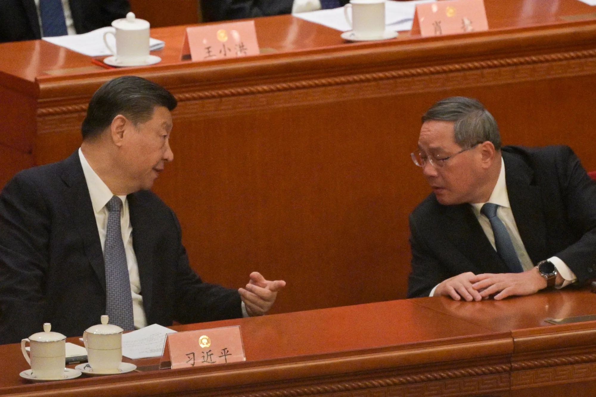 Xi Jinping speaks with&nbsp;Li Qiang during the opening ceremony of the Chinese People's Political Consultative Conference,&nbsp;on March 4.