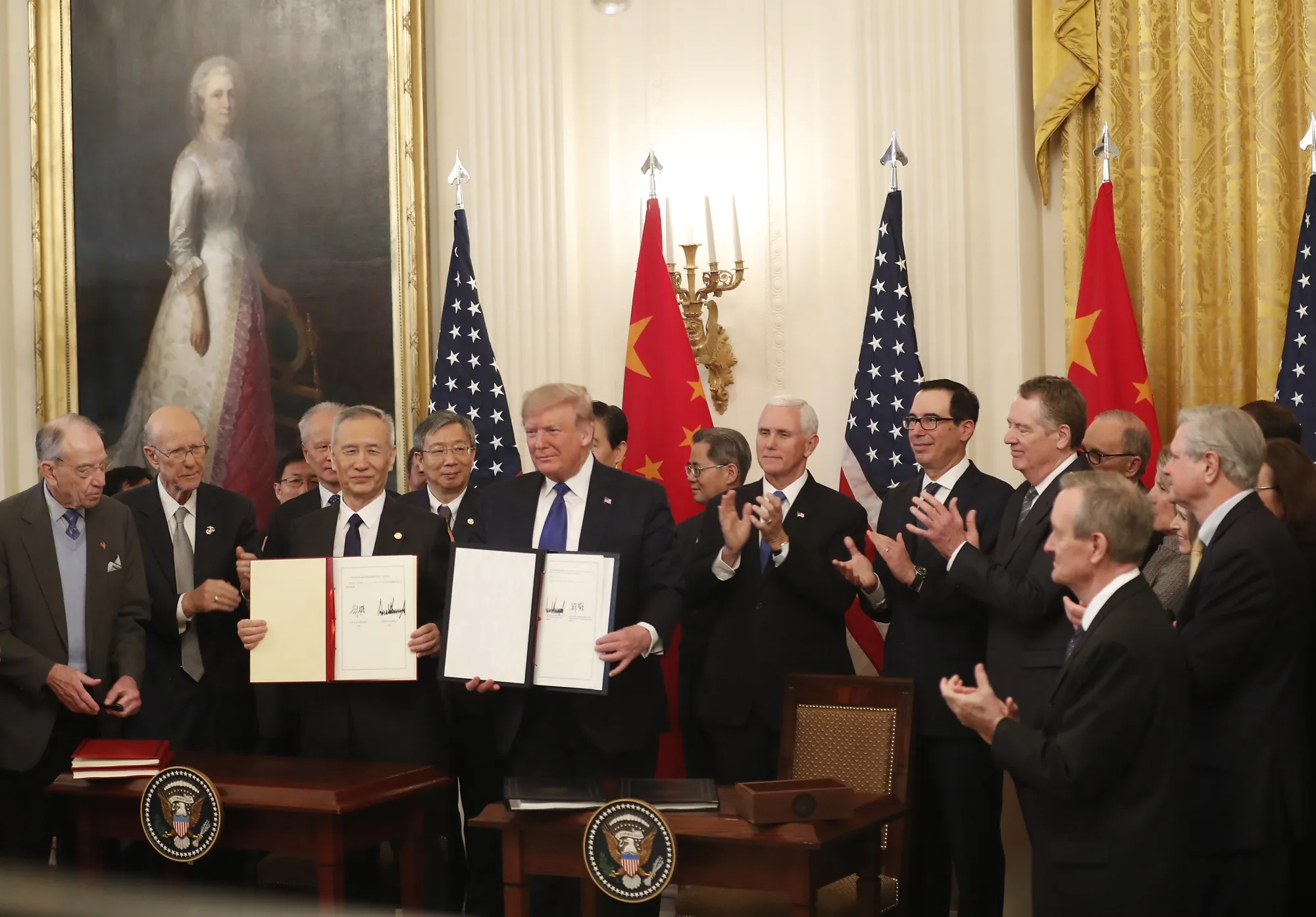 Donald Trump, center, and Liu He, left, display the signed U.S.-China "phase-one" trade agreement during a ceremony in Washington on Jan. 15.