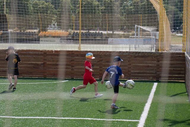 Children play football in a stadium where a lot of shells fell in Chernihiv, Ukraine, on Monday, July 4, 2022. Photographer: Andrew Kravchenko
