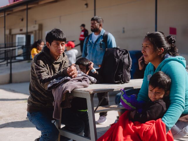 Una familia ecuatoriana espera la llegada de un autobús a Nueva York patrocinado por el estado de Texas.