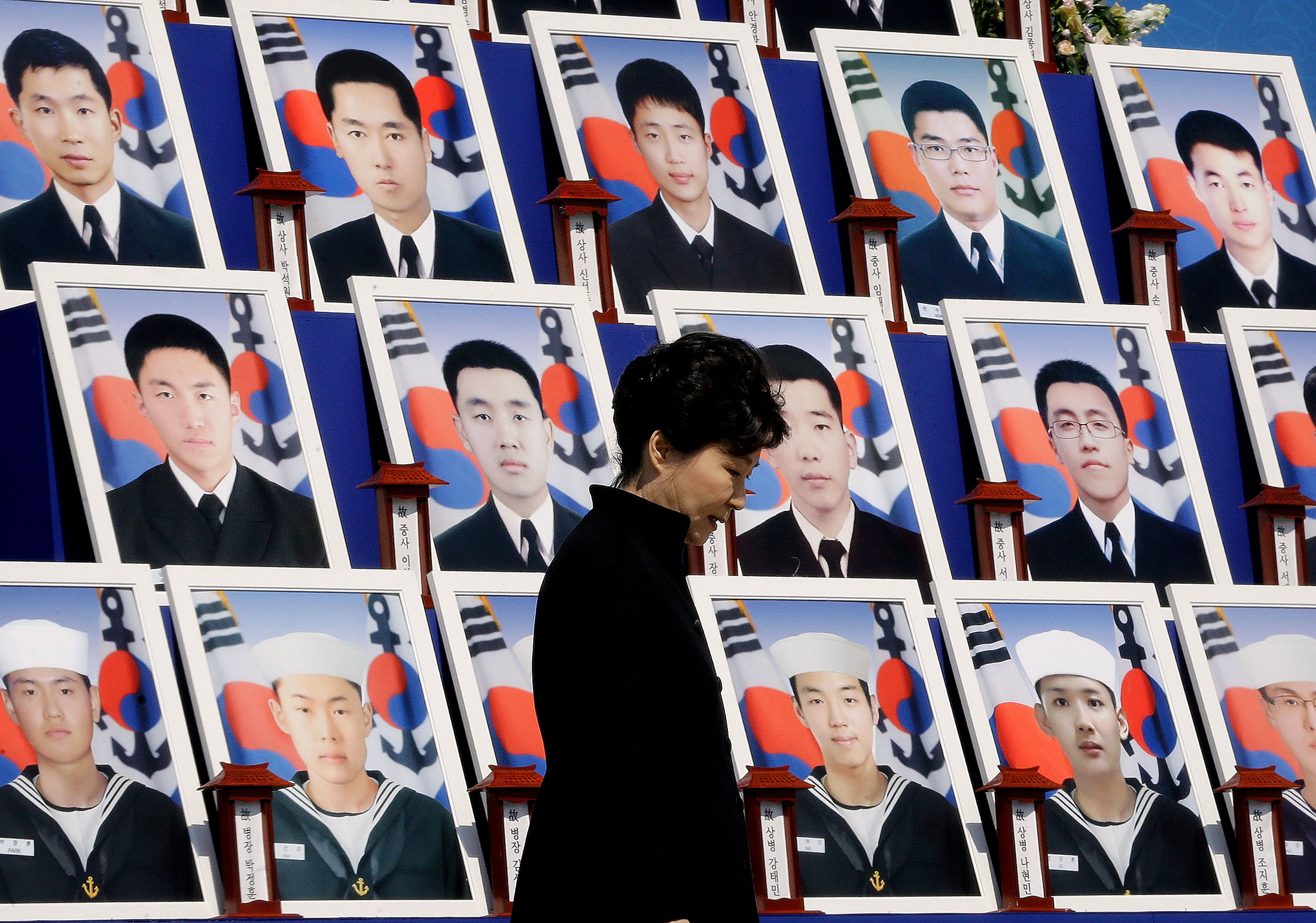 South Korean President Park Geun-Hye passes portraits of the 46 deceased sailors from the South Korean naval ship Cheonan during a ceremony to mark the fifth anniversary of the sinking of the ship at Daejeon National Cemetery in Daejeon, South Korea, on March 26, 2015.

