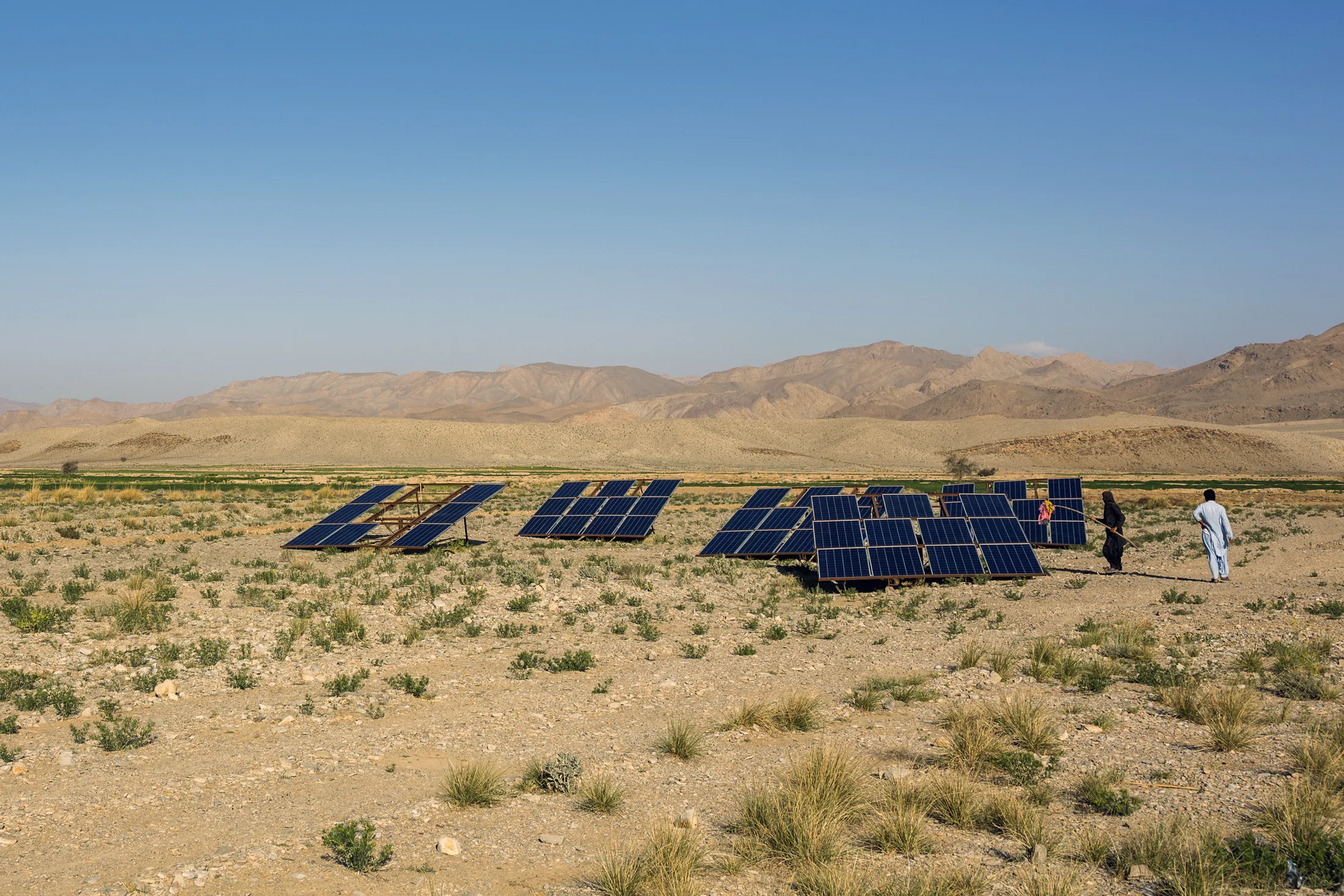 A farmer cleans solar panels in a field in Baluchistan region of Pakistan.