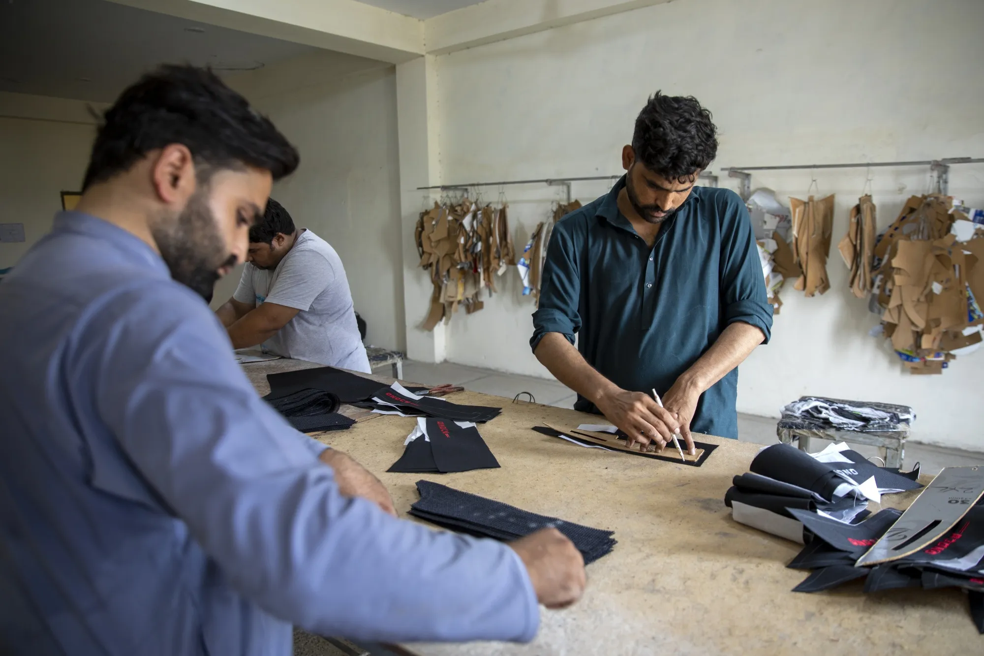 Workers cut leather fabrics on a production line at a&nbsp;factory in Sialkot, Pakistan.