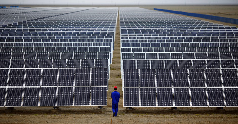 A worker inspects solar panels northwest of Lanzhou, Gansu Province.