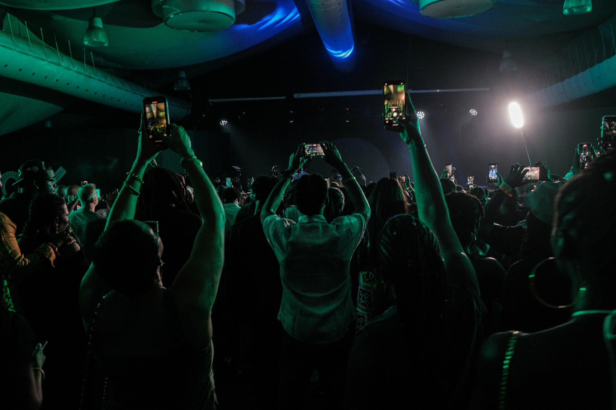 Audience members recording and enjoying a live music performance at the Art X Live event in Lagos.