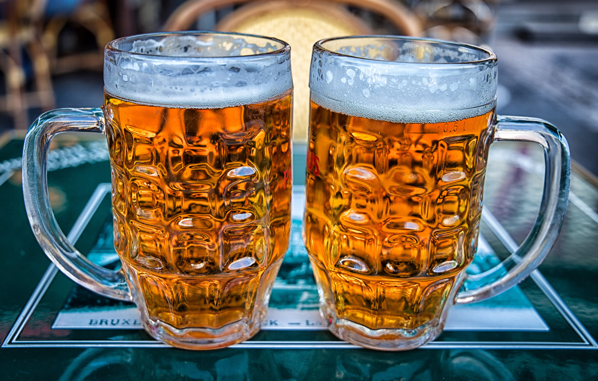 Two Mugs of amber-colored Beer.
